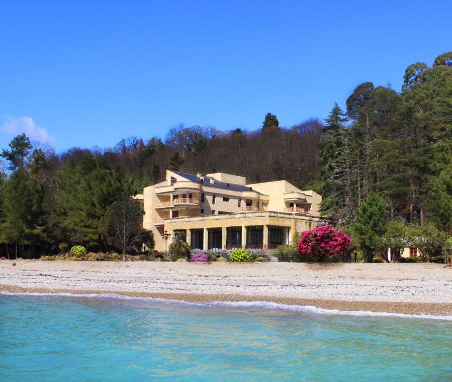 a large house on a beach next to the water at Резиденция Президента в Мюссере in Miusera