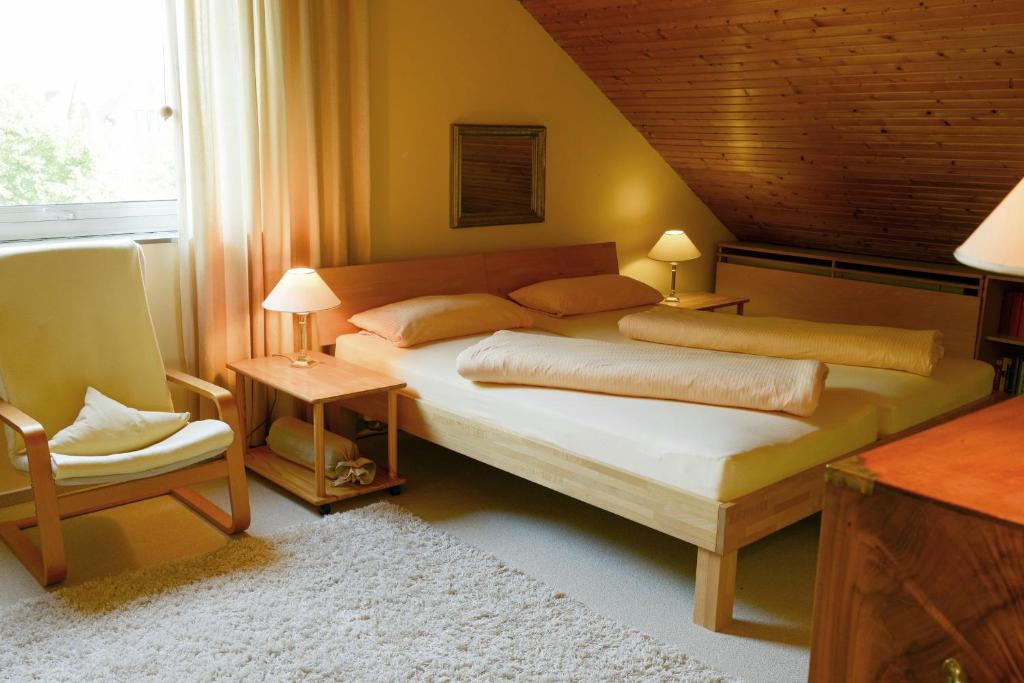 - une chambre avec un grand lit et une chaise dans l'établissement Strandhaus-Susi, à Cuxhaven