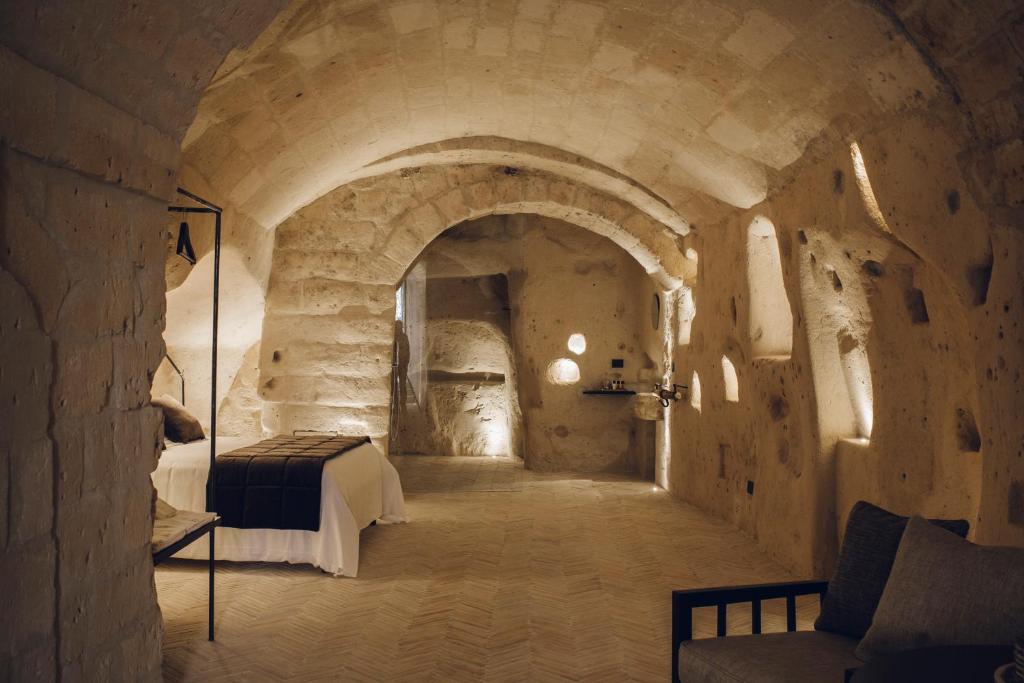 a bedroom with a bed in a stone tunnel at Palazzotto Residence&Winery in Matera