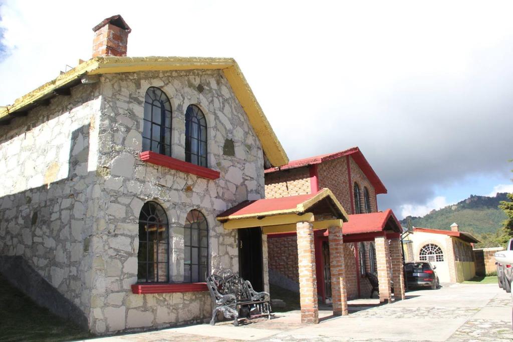 ein Steingebäude mit einer Bank davor in der Unterkunft Hotel Real de San Antonio in Estanzuela