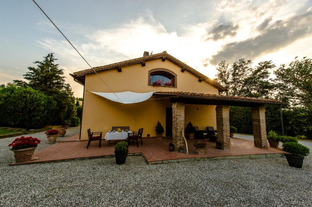 a small house with a patio with a table at La Casa Degli Olmi in Empoli