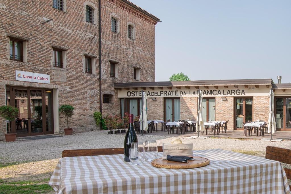a table with a bottle of wine on it in front of a building at Hotel Casa a Colori Venezia in Dolo