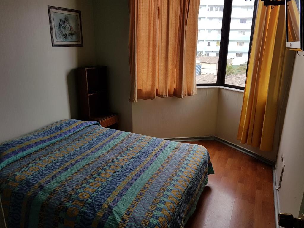 1 dormitorio con 1 cama frente a una ventana en Resivic en Antofagasta