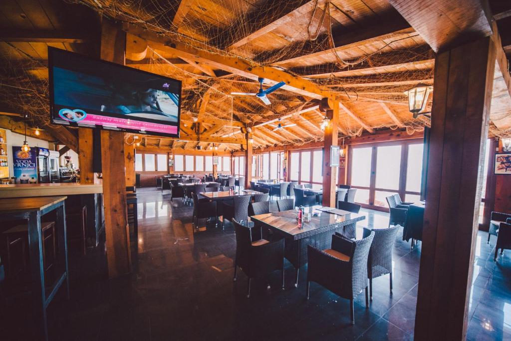 a restaurant with tables and chairs and a flat screen tv at Apartments Horizont in Budva