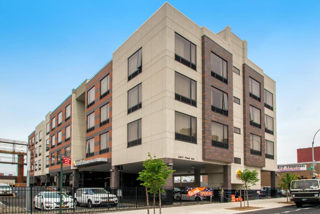 a building on a street with cars parked in front of it at Comfort Inn & Suites near Stadium in Bronx