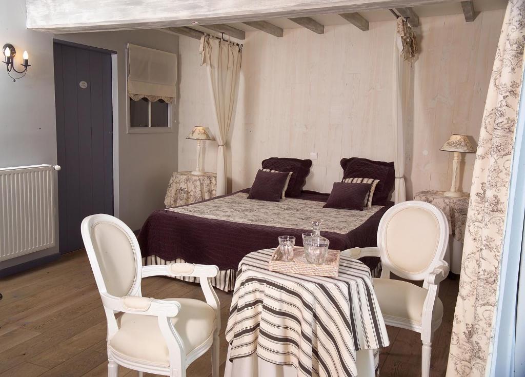 a bedroom with a bed with a table and chairs at Côte d&#39;Opale - La Ferme des Saules in Millam
