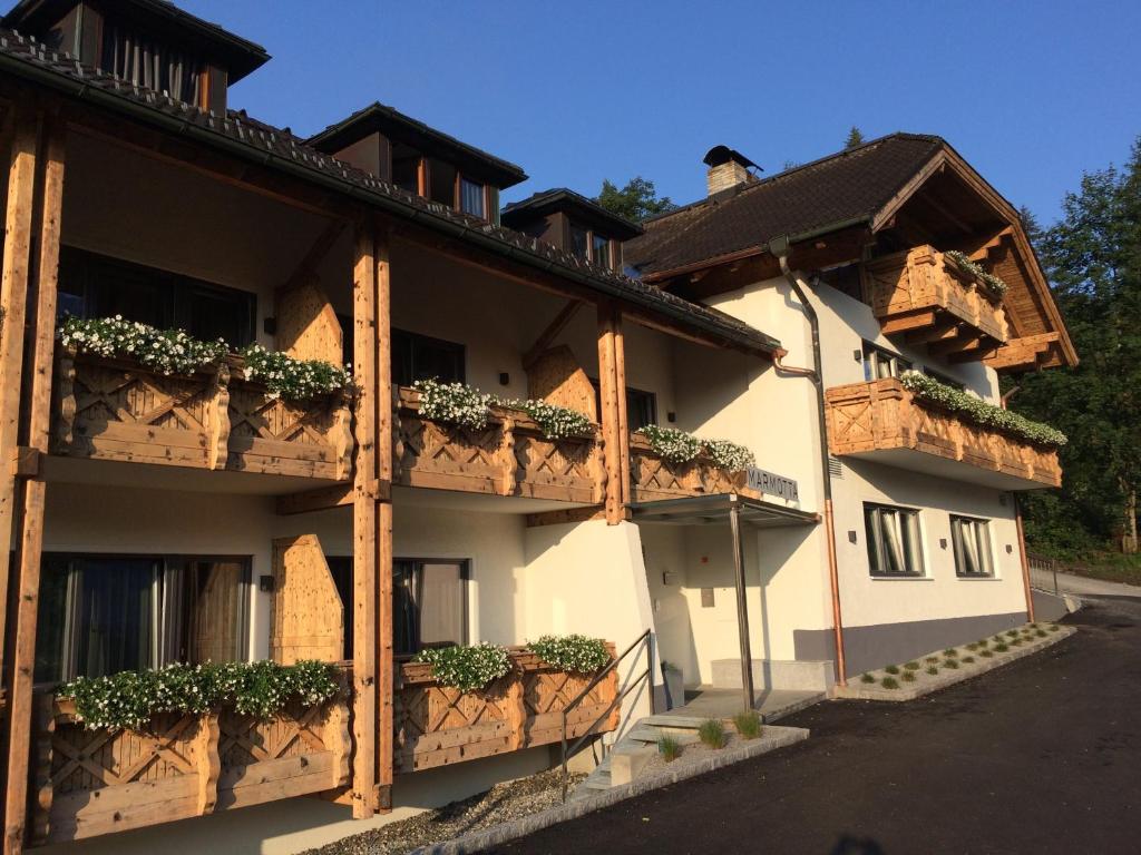 un edificio con macetas en los balcones en Marmotta Alpin hotel, en Mühlbach am Hochkönig