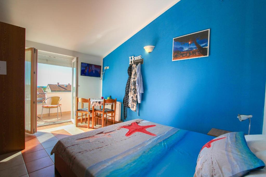 ノヴィグラード・イストラにあるApartments Mianiの青い壁のベッドルーム1室、星が付いたベッド1台が備わります。