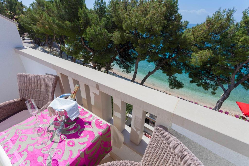 a table on a balcony with a view of the beach at Beach Apartments Ankora in Makarska