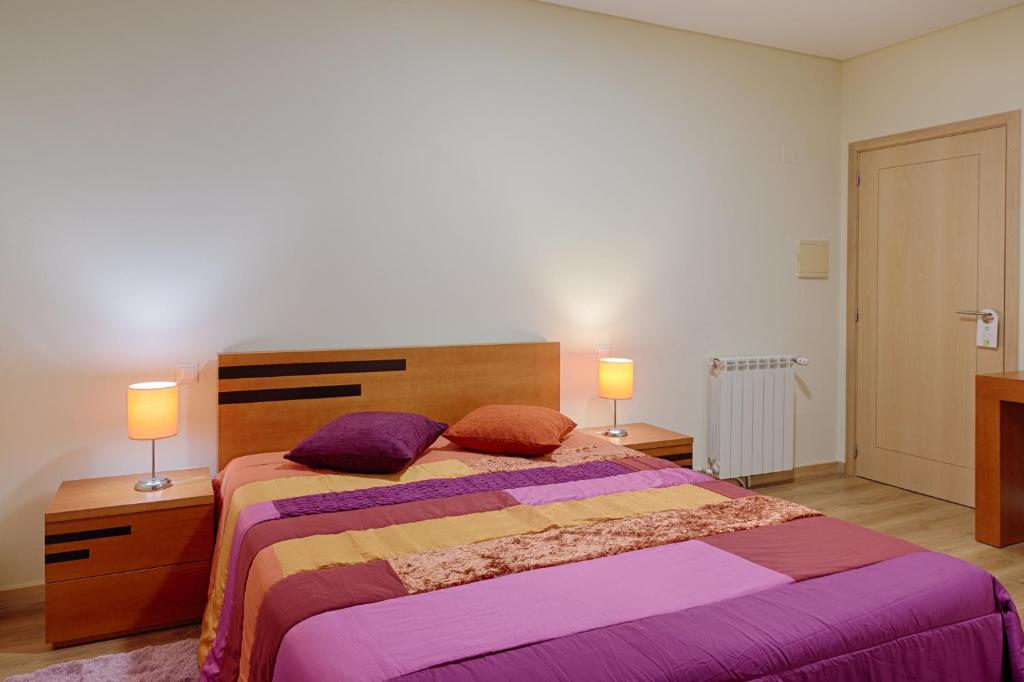 a bedroom with a large bed with two lamps at Casa Baranda in Ermida