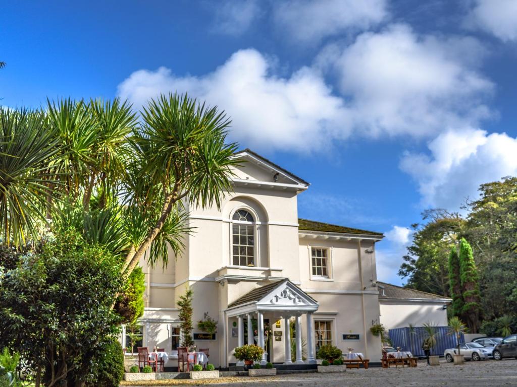 a white house with palm trees in front of it at Penventon Park Hotel in Redruth