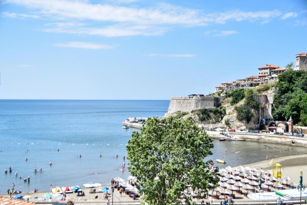 Ein Strand mit einem Haufen Leute im Wasser. in der Unterkunft Mala Plaza in Ulcinj