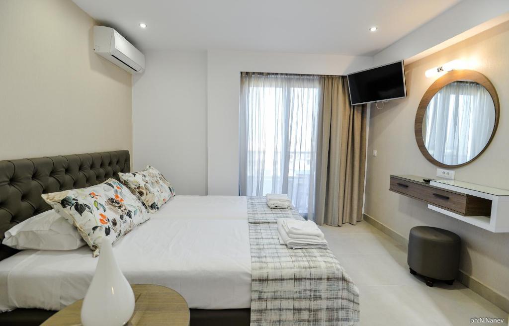 a bedroom with a large bed and a mirror at Island Dreams Rooms & Suites in Rhodes Town