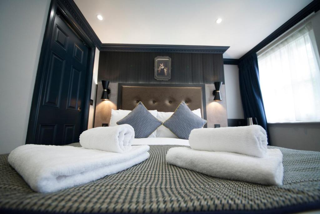 - une chambre avec un grand lit et 2 oreillers blancs dans l'établissement The House of Toby, à Londres