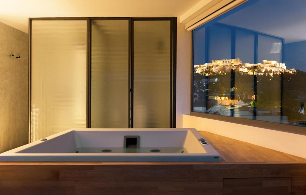 a large bath tub in a bathroom with a window at Acropolis View Luxury Apartment in Athens