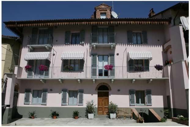 ein großes weißes Gebäude mit Blumen auf den Balkonen in der Unterkunft Cà Veja in Montà