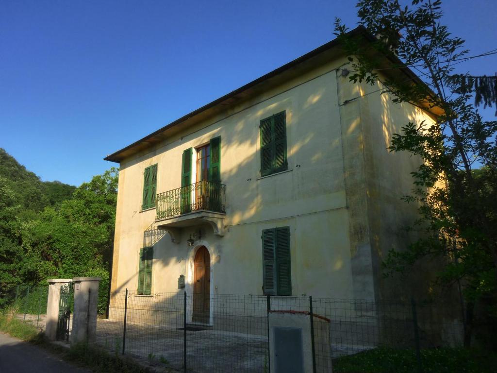 BagnoneにあるA House In Tuscanyの緑のシャッター付き窓のある白い大きな建物