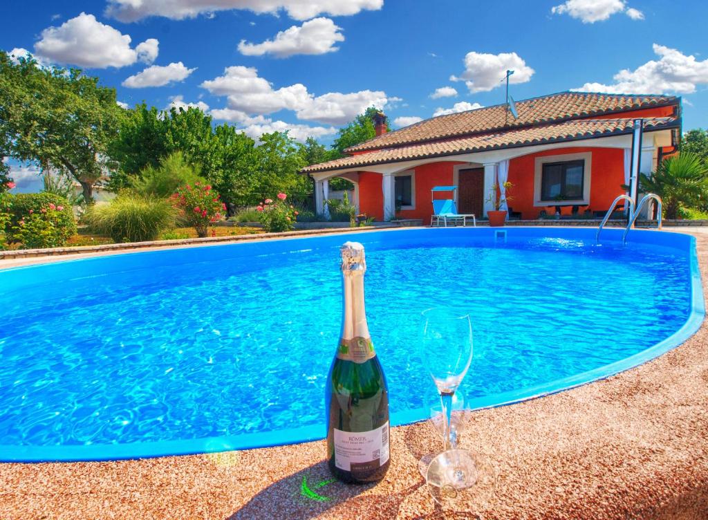butelkę wina przy basenie w obiekcie Holiday Home Villa Angelina 1233 w mieście Barban