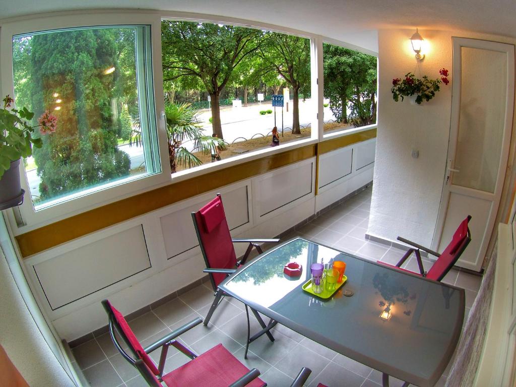 balcone con tavolo in vetro e sedie rosse di Apartment Suzana 2BR Split with balcony a Spalato (Split)