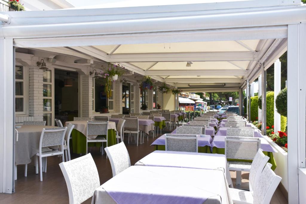an outdoor restaurant with white tables and chairs at Hotel Ristorante Fortuna in Cavallino-Treporti