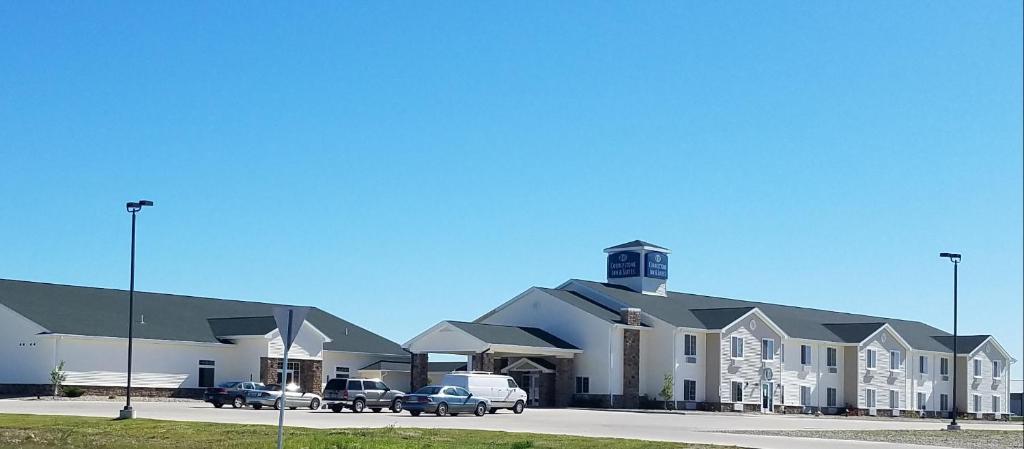 a large building with cars parked in a parking lot at Cobblestone Inn & Suites - Bottineau in Bottineau