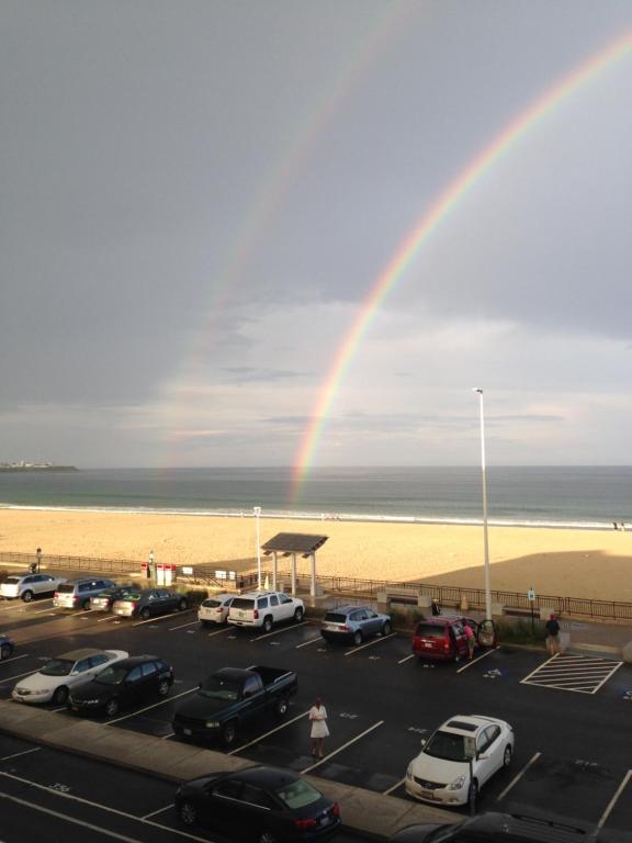 a rainbow over a parking lot next to the beach at Ocean Front condo in the heart of Hampton Beach in Hampton