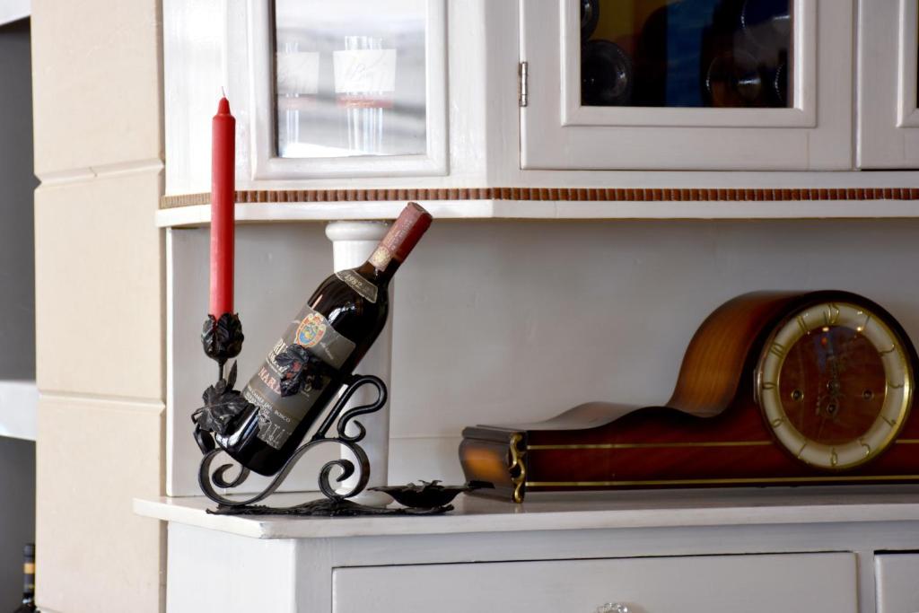 a bottle of wine on a shelf next to a clock at Hotel Ristorante Fortuna in Cavallino-Treporti