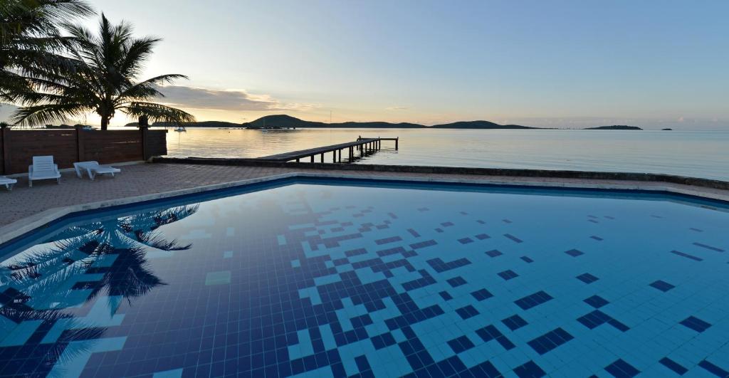 a swimming pool with a view of the water at Le Stanley Hôtel in Noumea
