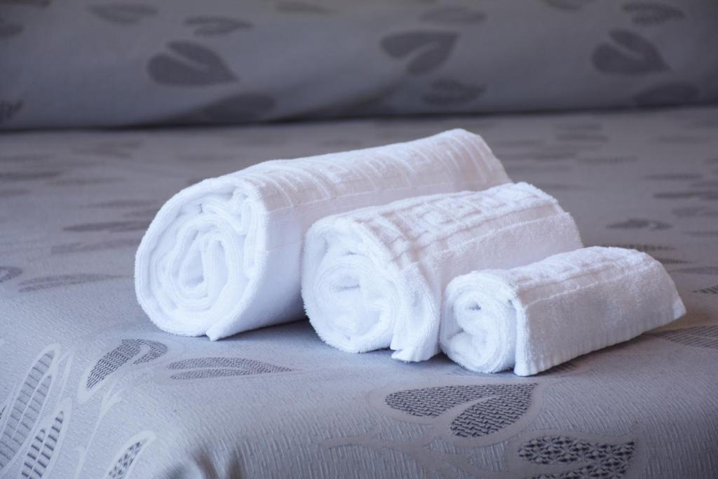 two rolled towels sitting on top of a bed at Hotel Ristorante Fortuna in Cavallino-Treporti