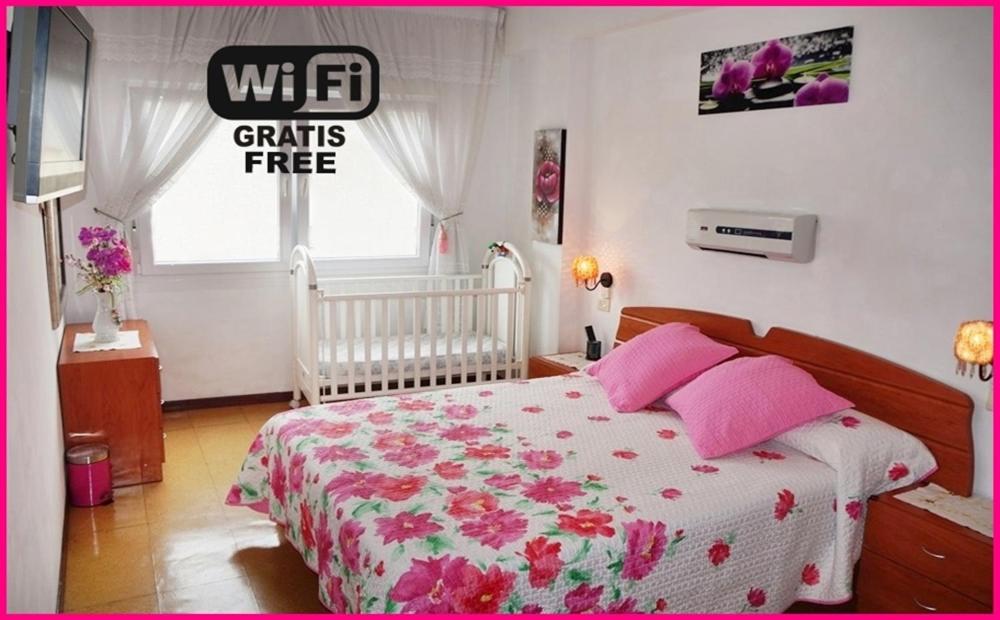 フィニステレにあるApartamento Paseo del Puertoのベッドルーム1室(ピンクの枕が付くベッド1台、窓付)