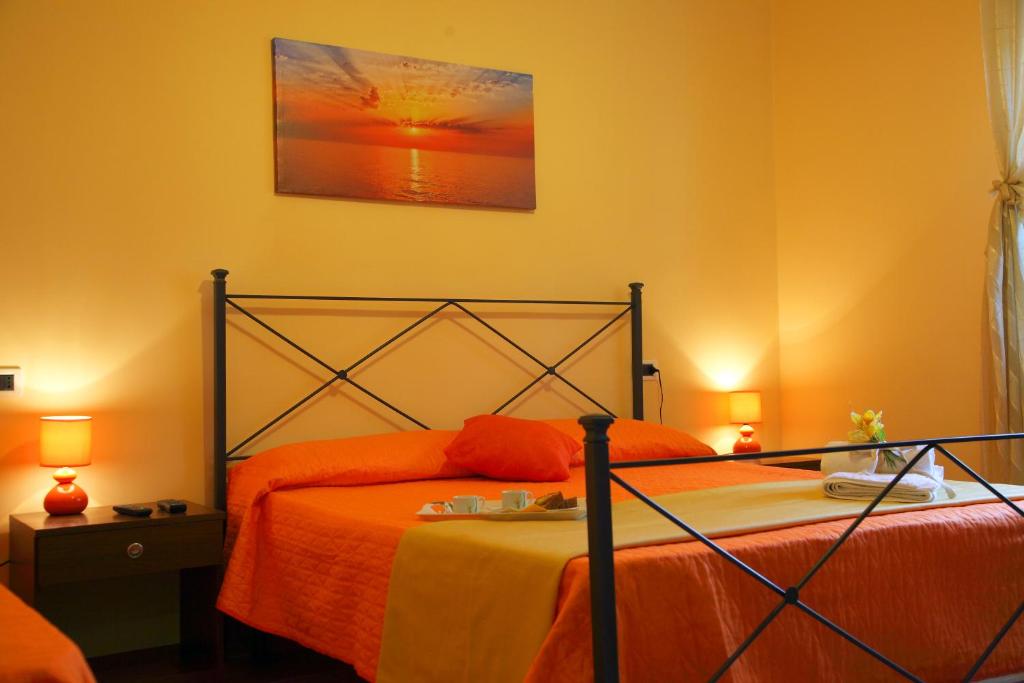 San SeverinoにあるB&B Le Querceのベッドルーム1室(オレンジ色のベッドカバー付)