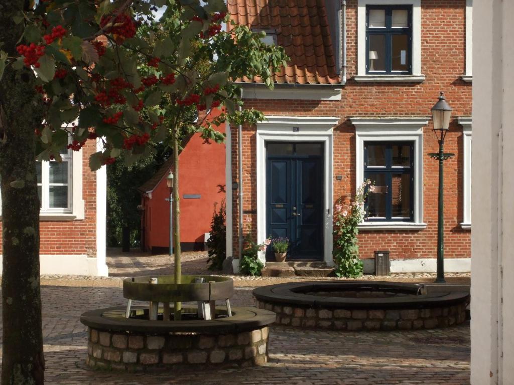 een gebouw met een blauwe deur en een boom bij Nattely I Viborg By in Viborg