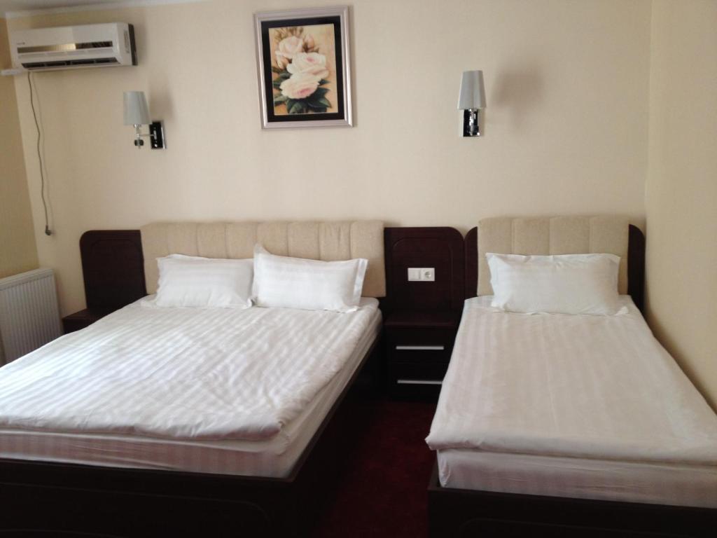 dos camas sentadas una al lado de la otra en una habitación en Hotel Mondial - Eforie Nord, en Eforie Nord