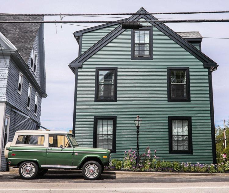 a green car parked in front of a blue house at GREAT ISLAND INN - A Modern Boutique Hotel in New Castle