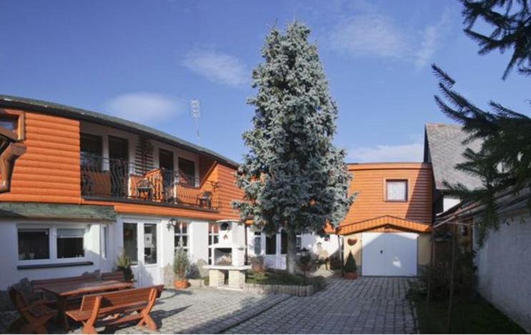 a house with a tree in front of it at Penzión Hubert in Zuberec