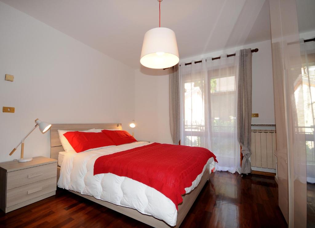 サン・ヴァンサンにあるAppartamento Centralのベッドルーム1室(赤と白のベッド1台、窓付)