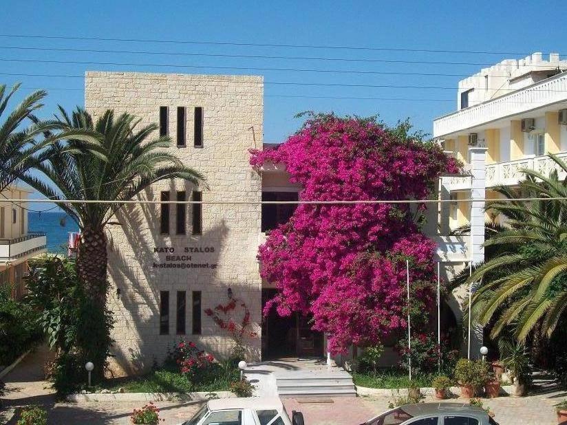 a building with pink flowers on the side of it at Kato Stalos Beach in Stalos