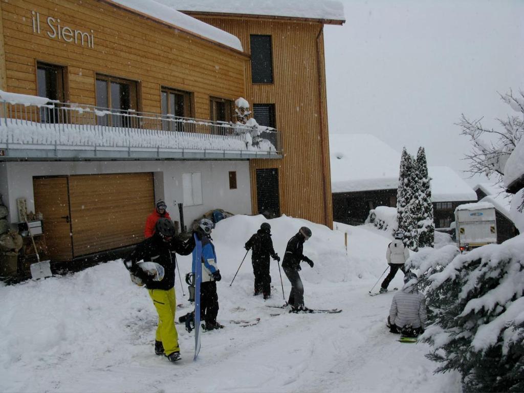 un gruppo di persone in piedi sulla neve fuori da un rifugio da sci di Casa il Siemi a Luven