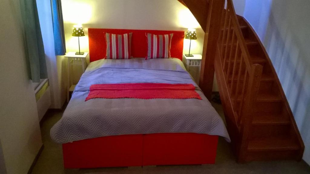 ein Schlafzimmer mit einem roten Bett und einer Treppe in der Unterkunft Apartman Lidicka in Marienbad