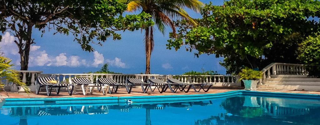 grupa krzeseł siedzących obok basenu w obiekcie Silver Seas Hotel w mieście Ocho Rios