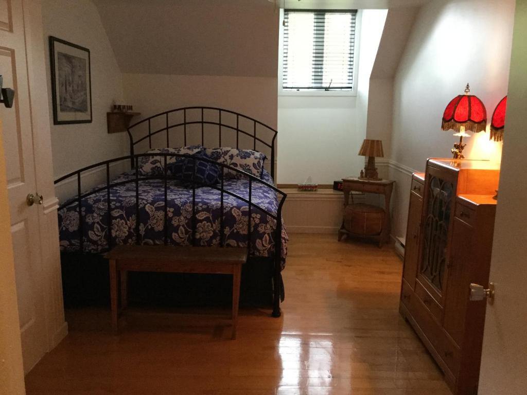 a bedroom with a bed and a wooden floor at La Maison des Éboulis in Victoriaville
