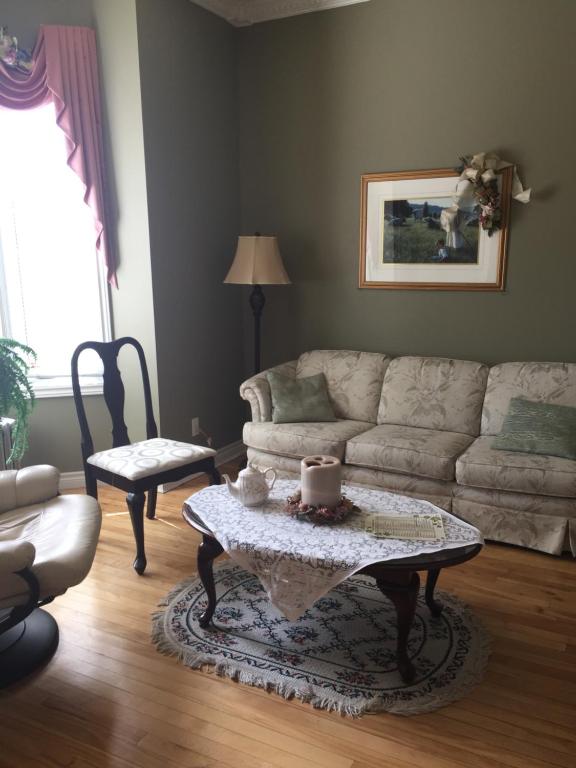 a living room with a couch and a table at Le Gîte De La Sagouine in Bouctouche