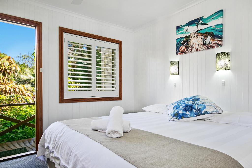 Dormitorio blanco con cama y ventana en Lorhiti Apartments, en Lord Howe