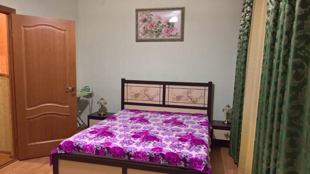 アドレルにあるGuest house Yugのベッドルーム(紫色の掛け布団付きのベッド1台付)