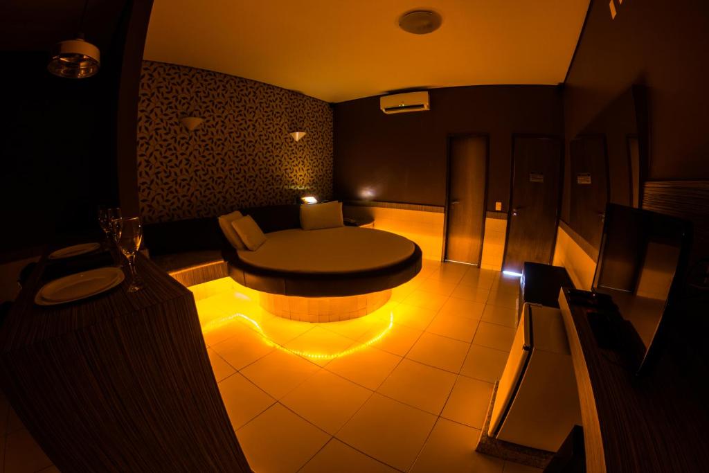 Villa Verde Motel (Adults Only) في فورتاليزا: غرفة مع طاولة مستديرة مع ضوء على الأرض