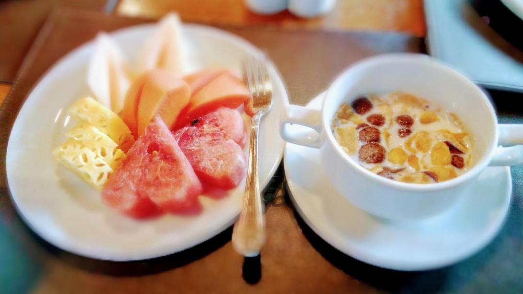 a plate of fruit and a cup of coffee on a table at Chang Buri Resort & Koh Chang Hillside in Ko Chang