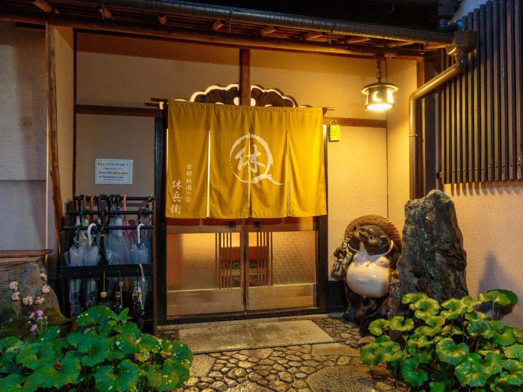 una entrada a un edificio con una cortina amarilla en Gion Ryokan Q-beh en Kioto