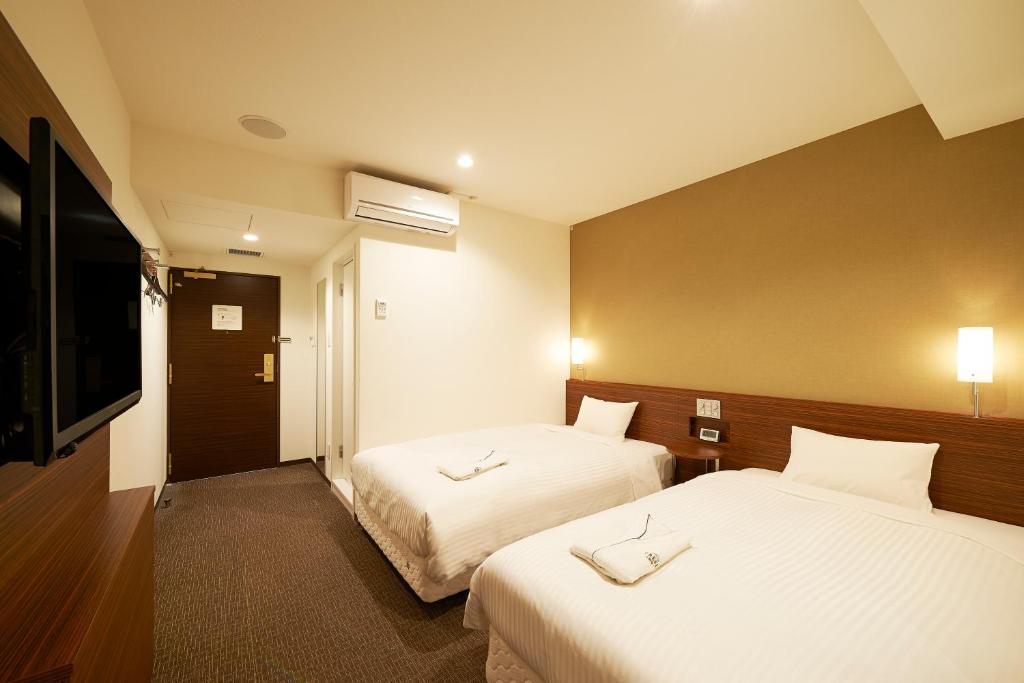 Postel nebo postele na pokoji v ubytování Sotetsu Fresa Inn Tokyo Tamachi