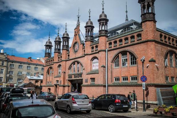 a large brick building with cars parked in front of it at Old Town Apartment / Igielnicka in Gdańsk