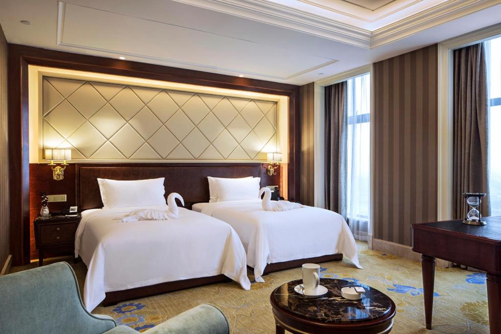 a hotel room with two beds and a piano at Chengdu Jin Yun Hotel in Chengdu